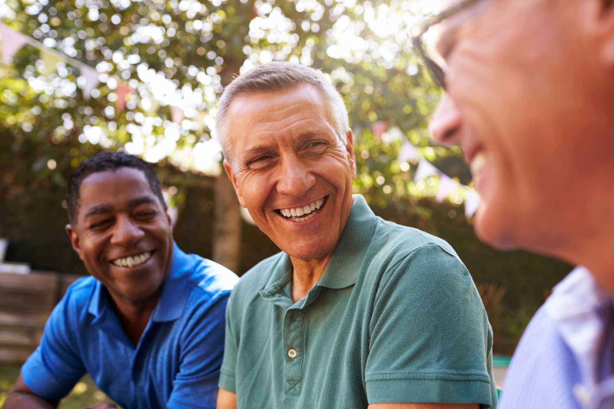 mature-male-friends-socializing-in-backyard-together
