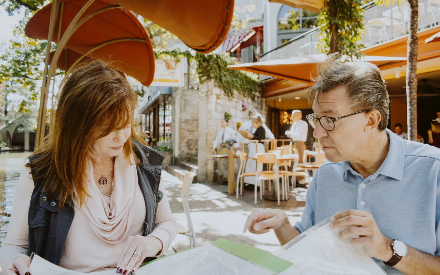 Mature couple reviewing financial and estate planning documents together at home as they prepare for retirement.