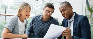 Professional couple meeting with a financial advisor to discuss retirement planning and retirement income strategies.