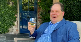 Man relaxing outdoors with a glass of wine, enjoying the freedom and lifestyle that retirement can offer.