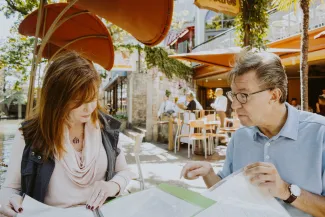 Mature couple reviewing financial and estate planning documents together at home as they prepare for retirement.