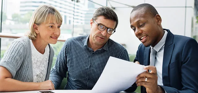 Professional couple meeting with a financial advisor to discuss retirement planning and retirement income strategies.
