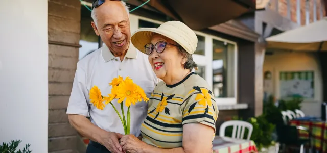 Retired couple walking hand in hand outdoors, representing retirement planning for couples.